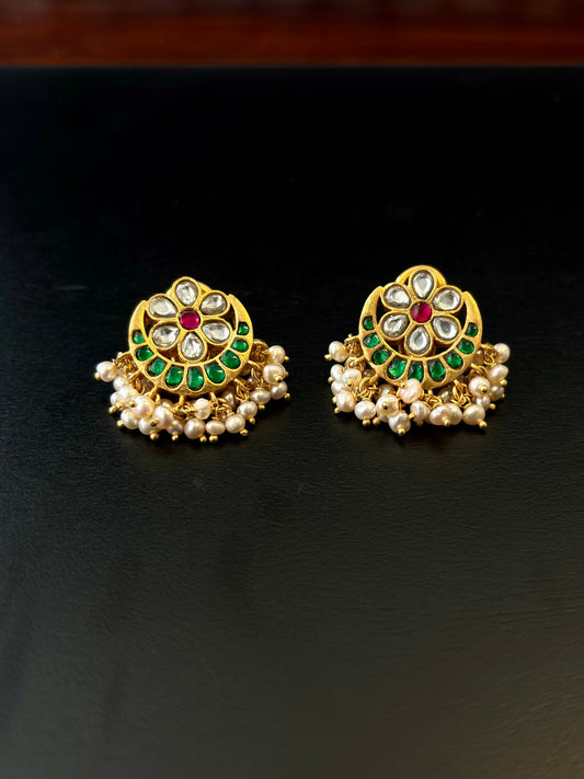 Pair of gold earrings with green and red stones on a black background, 92.5 silver earrings