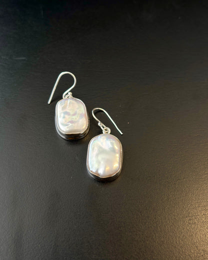 Pair of silver earrings with real water pearl on a dark surface, 92.5 silver