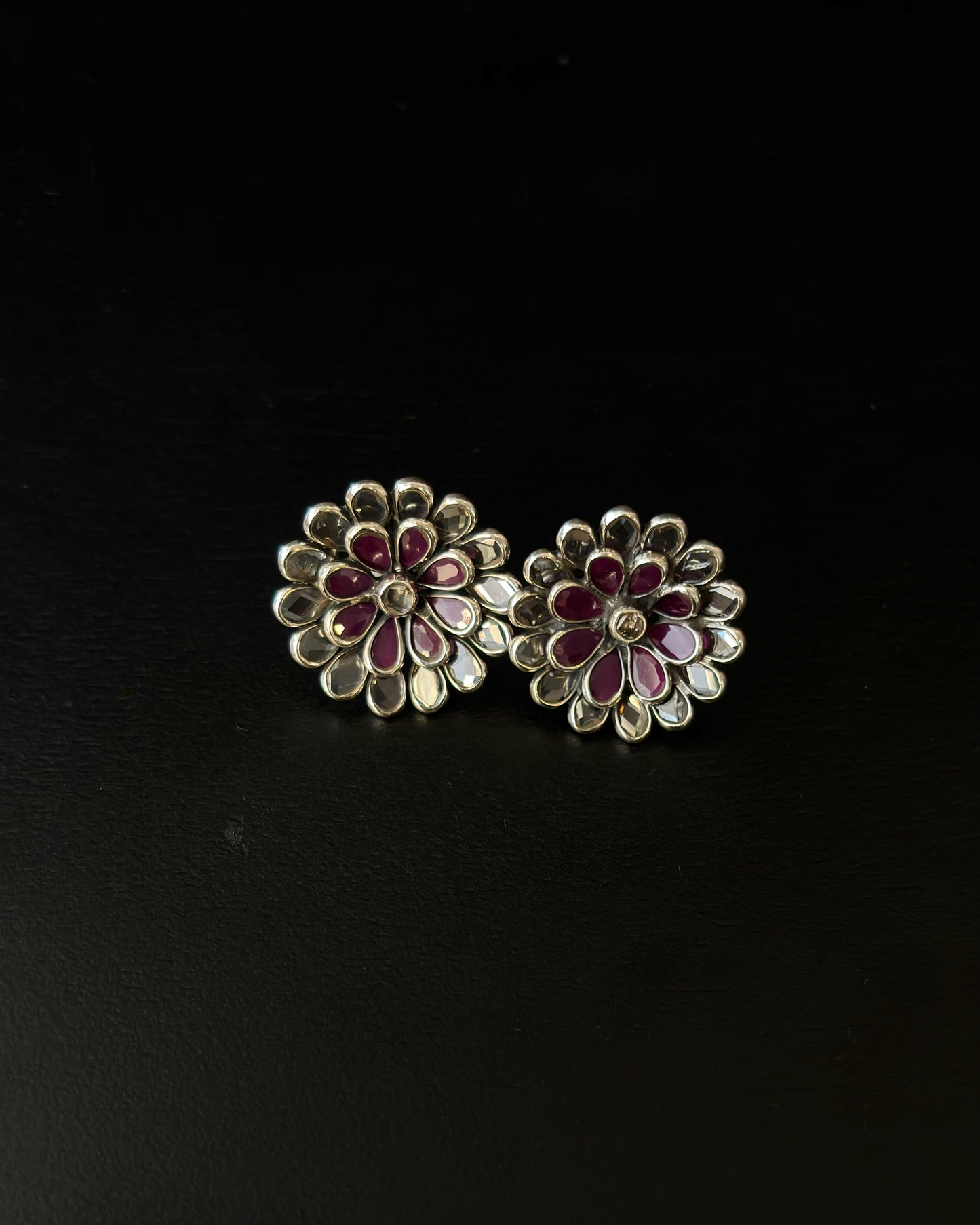 Floral earrings with red and gold details on a black background