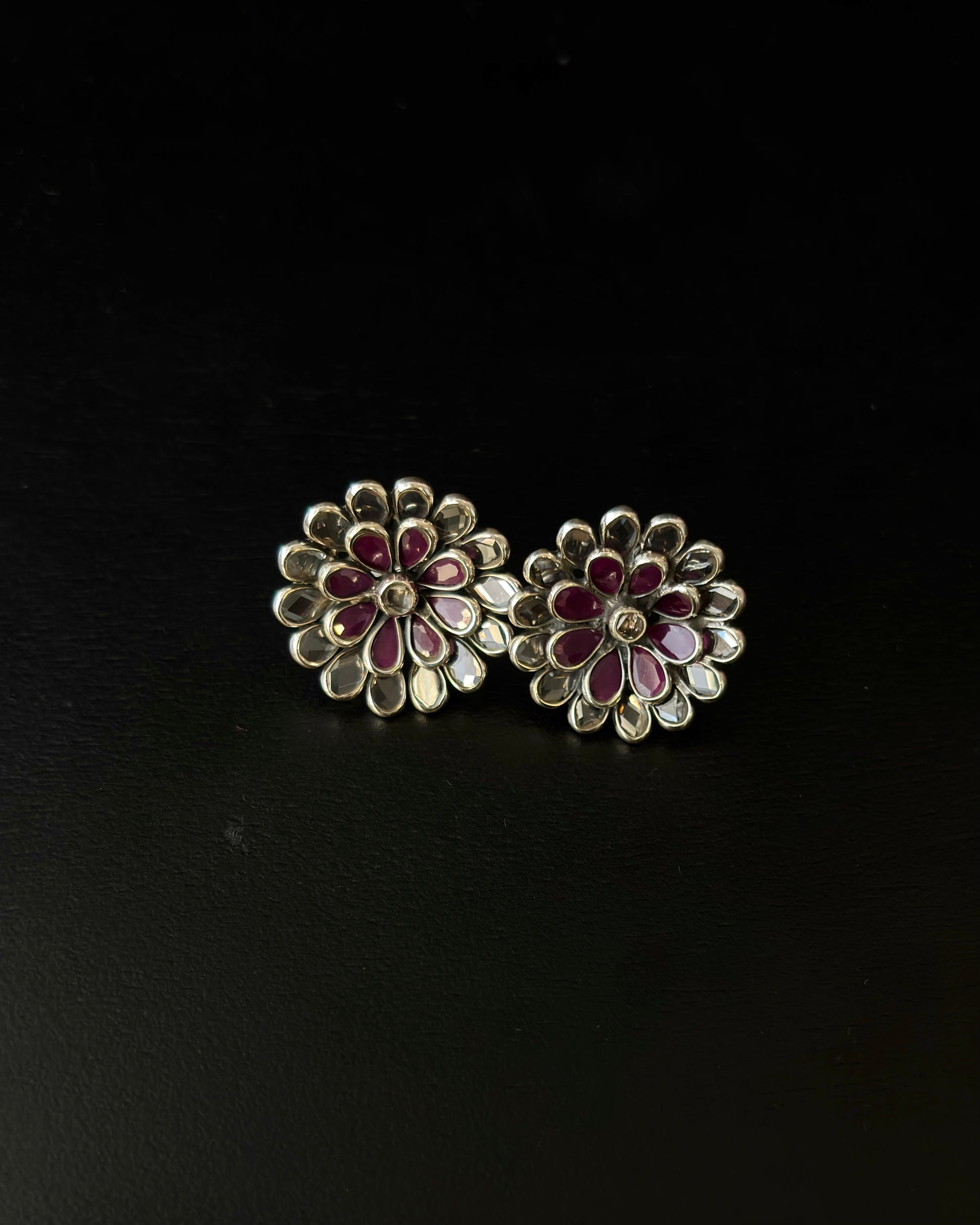 Floral earrings with red and gold details on a black background