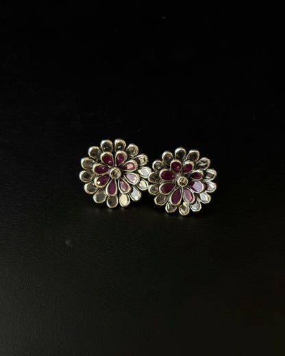 Floral earrings with red and gold details on a black background