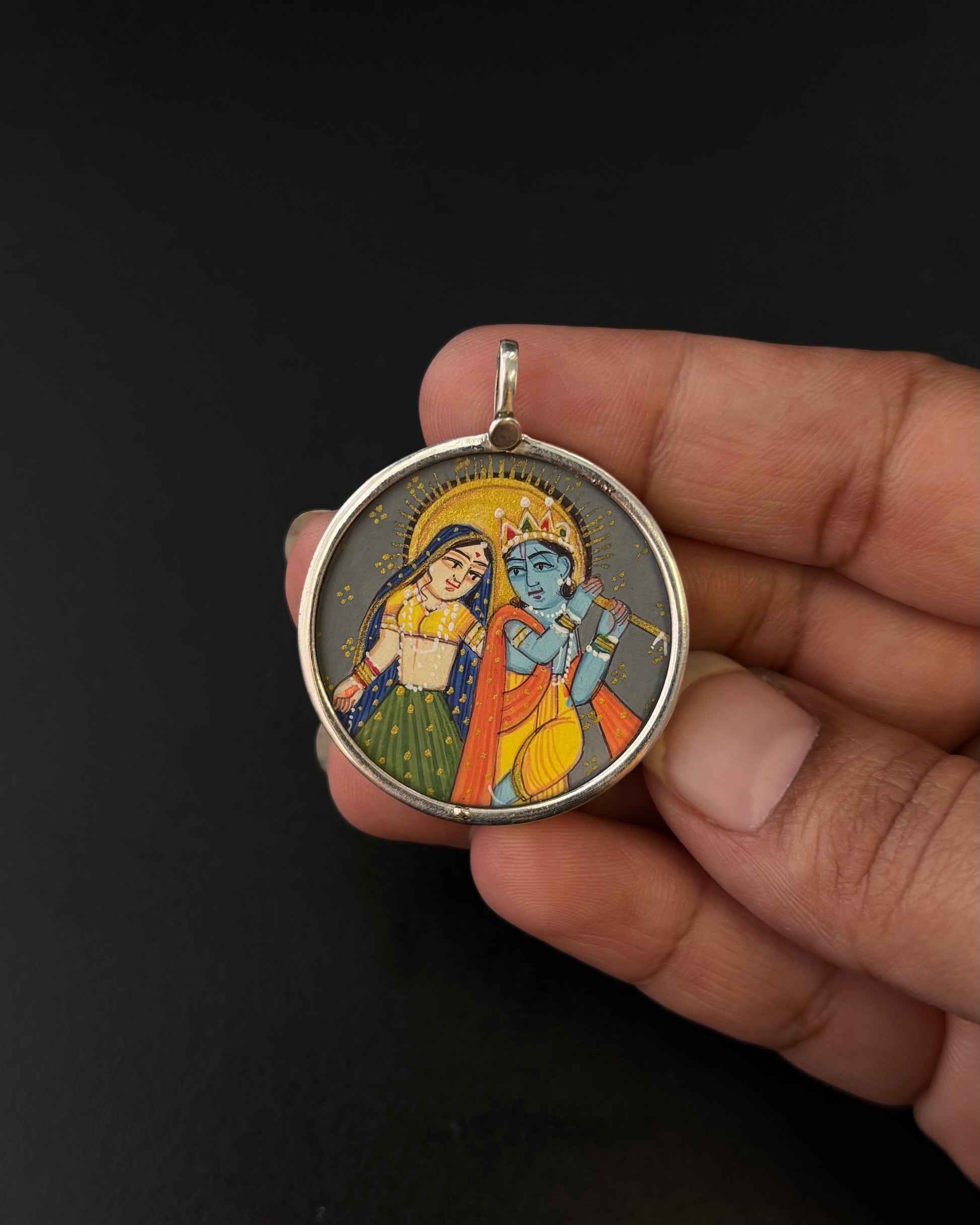 Round pendant with illustrations held by a hand against a black background, Radha Krishan Pichwai, Silver Pendant, Miniature paintings Silver Pendant, pure 92.5 Silver Pendant