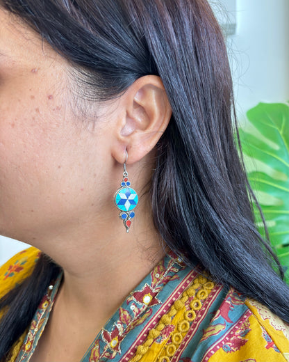 92.5 Silver earrings, Natural stones Earrings, Close-up of a person wearing a colorful earring with a blue gemstone, against a blurred background.