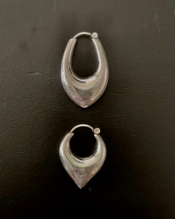 Pair of silver hoop earrings on a dark surface