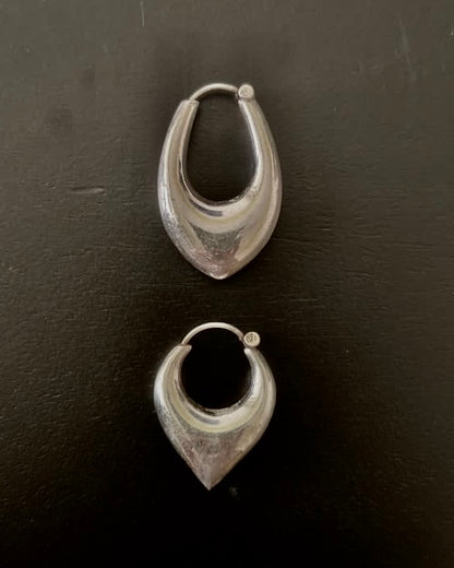 Pair of silver hoop earrings on a dark surface